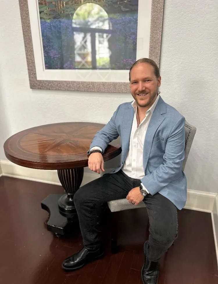 Dr. Karan Narwal sitting in a relaxed office space next to a wooden table